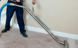 Professional operating a liquid removal machine on a carpeted floor in Boston, MA